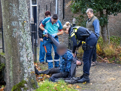 Man glijdt uit en valt in het water